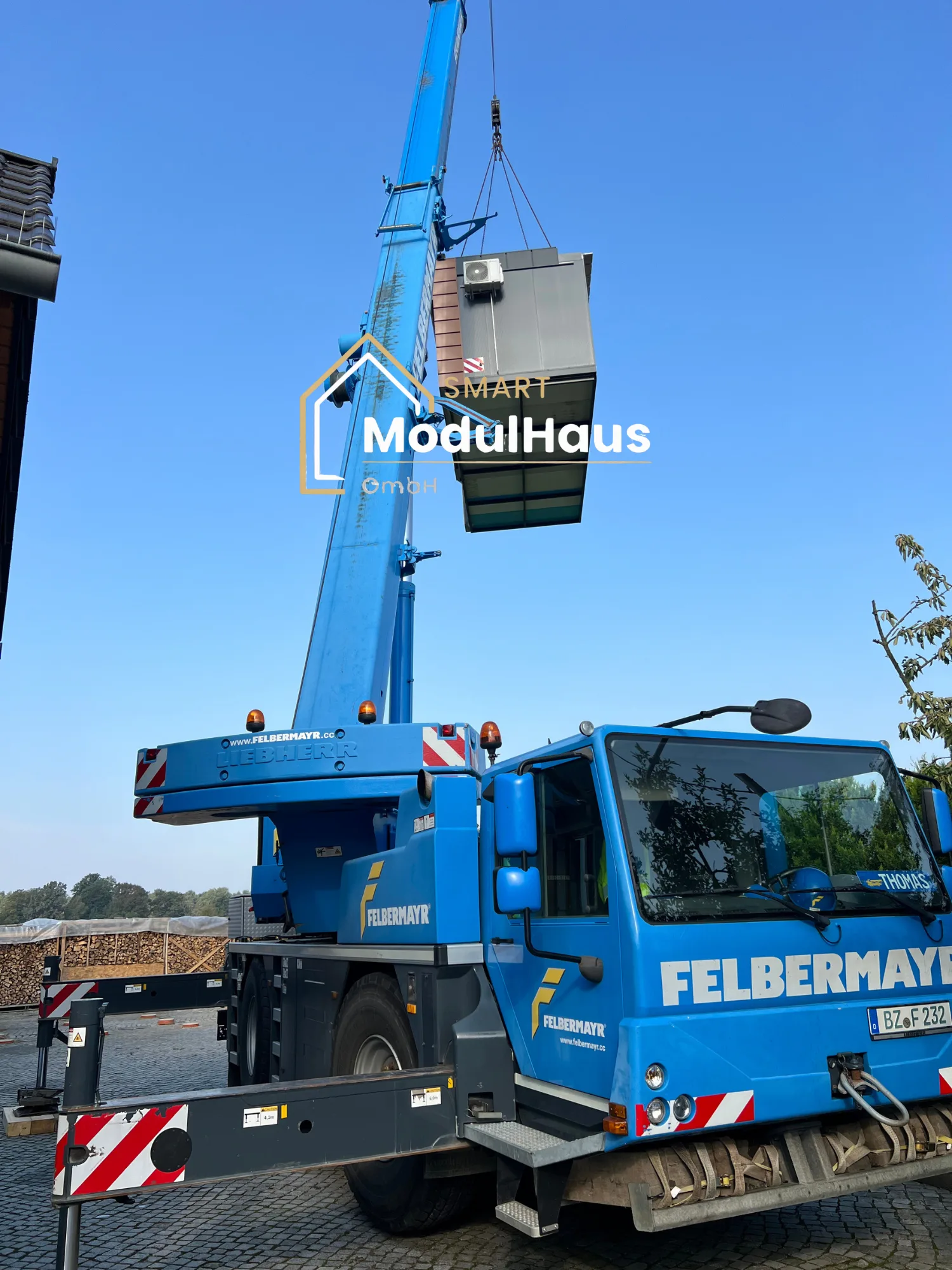 Mobilkran mit angehobenem Wohnmodul auf der Baustelle