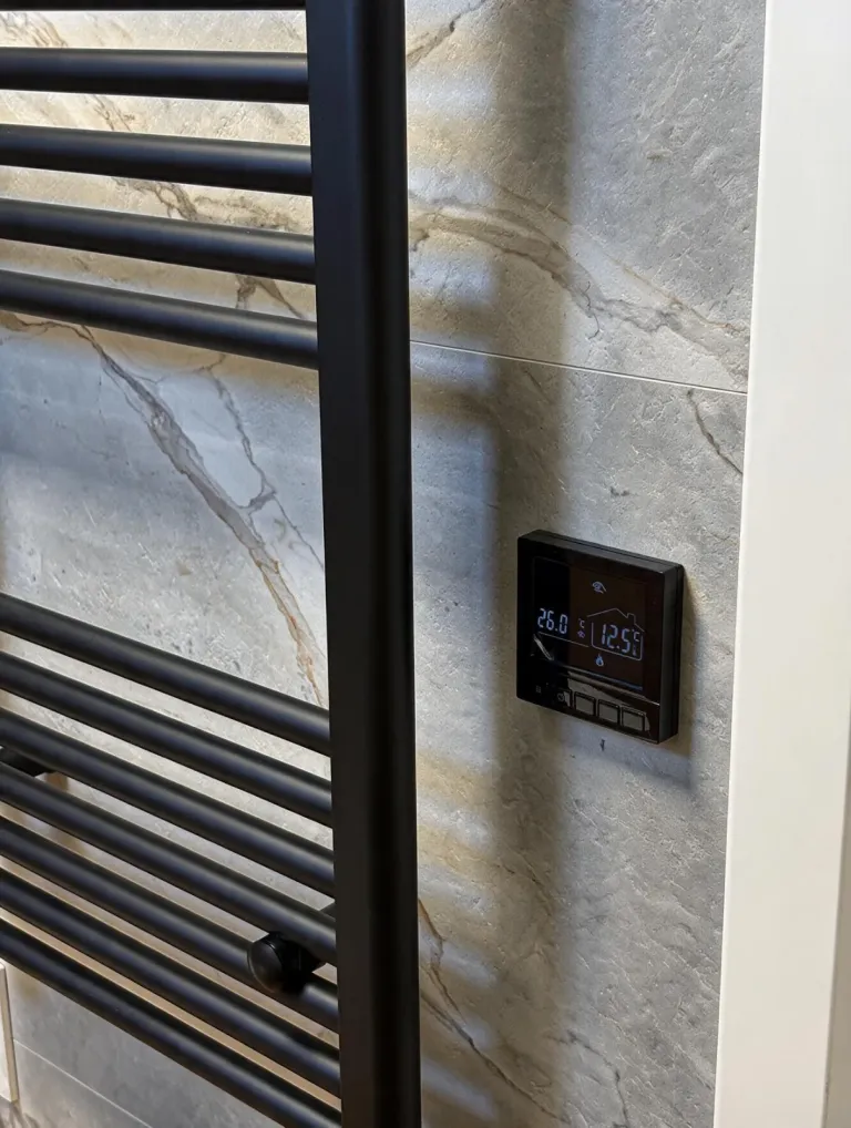 SPC-Vinylfliesen in Marmoroptik mit Handtuch-Heizkörper und Thermostat der Fußbodenheizung